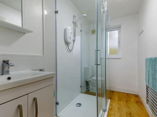 a bathroom with a glass shower and a sink at Hall Farm Bungalow in Shirley