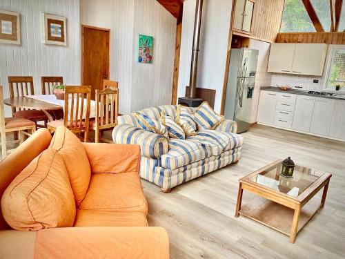 a living room with a couch and a table at Casa al lado de playa c/ juegos niños- mascotas in Los Molles