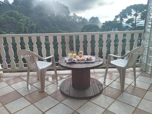 uma mesa com uma bandeja de comida numa varanda em Pousada Campos SONHO MEU em Campos de Jordão