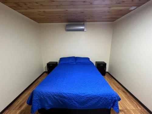 1 dormitorio con 1 cama con colcha azul en Hospedaje Santa Barbara, en Santa Bárbara