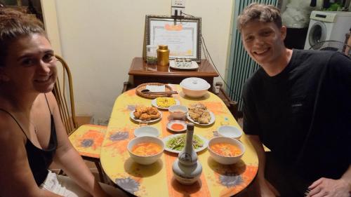 a man and a woman sitting at a table with food at Yen Binh Homestay in Ninh Binh