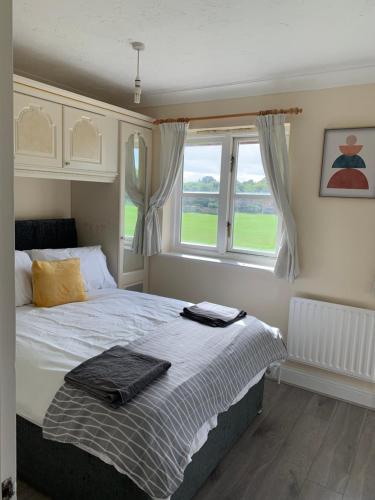 1 dormitorio con cama y ventana en Large, Spacious 3 Bedroom Sleeps 6, Apartment for Contractors and Holidays in Lewisham, Greater London - 1 FREE PARKING SPACE & FREE WIFI, en Londres