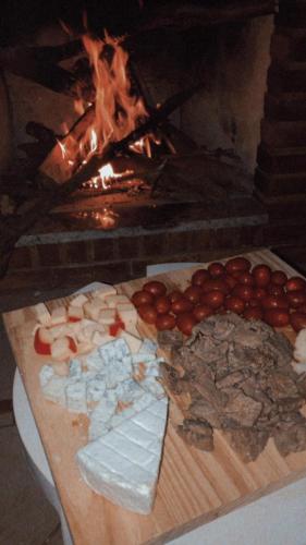 a table of food in front of a fireplace at Casa de Campo I Cond Ninho Verde II in Pardinho