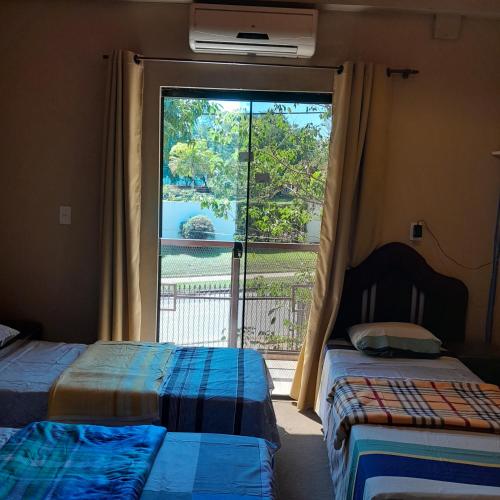 two beds in a room with a large window at Hospedaje San Miguel in Luque