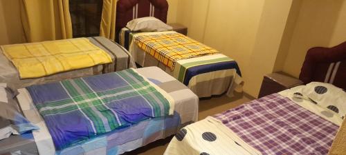 a room with four beds with colorful blankets at Hospedaje San Miguel in Luque