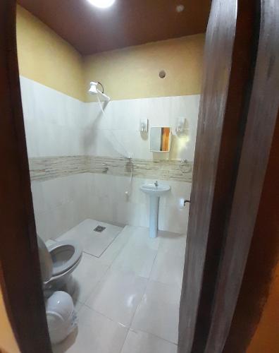 y baño con aseo y lavamanos. en Hospedaje San Miguel, en Luque