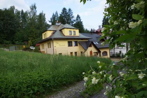a large yellow house in the middle of a field at Villa Goździk in Wisła