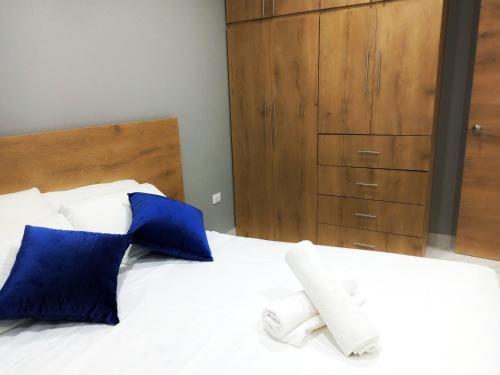 a bedroom with a bed with blue pillows and a dresser at Edificio Nuevo Consulado Americano 4Apt Coliving Ecuador in Guayaquil