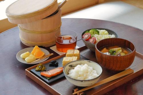 uma mesa coberta com tigelas de comida e uma bebida em cyashitsu ryokan asakusa em Tóquio