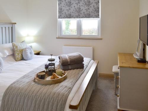 a bedroom with a bed with a tray of food on it at Robin Cottage - Ukc3436 in Newton Abbot