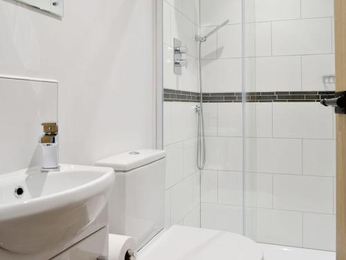 a white bathroom with a sink and a shower at Robin Cottage - Ukc3436 in Newton Abbot