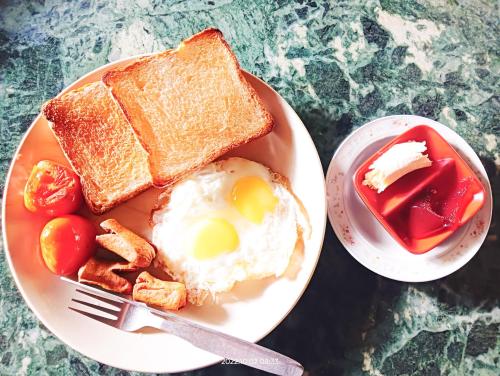 a plate of breakfast food with eggs and toast at Hotel Butterfly - Peaceful Garden for Nature Lovers in Sauraha