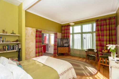 Braemar House في أومارو: غرفة نوم بسرير وطاولة وتلفزيون