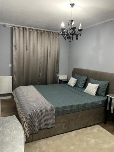 a bedroom with a bed and a chandelier at Tiberiu Ricci Apartament in Sibiu