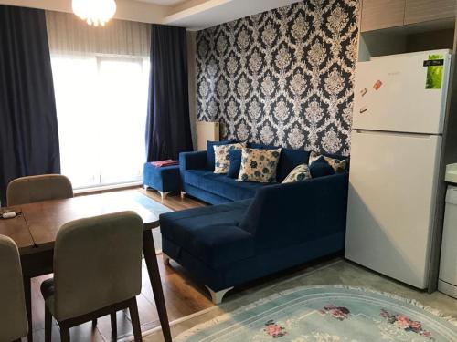 uma sala de estar com um sofá azul e um frigorífico em medikule 3 em Istambul