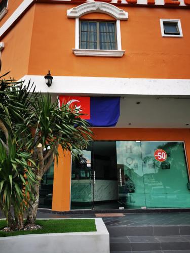 un edificio naranja con una señal de stop en la ventana en SUNTEC HOTEL, en Johor Bahru