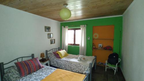 a bedroom with two beds and a green wall at El viejo boliche in Trevelin