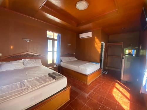 a bedroom with two beds and a window at Rainbow Bungalow Haadrin Koh Phangan in Haad Rin