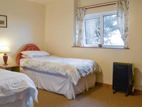 1 Schlafzimmer mit 2 Betten und einem Fenster in der Unterkunft The Cottage Gallt Y Balch in Bodorgan