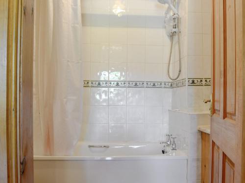 a bathroom with a tub and a shower and a sink at Bryn Gefeiliau in Capel Curig