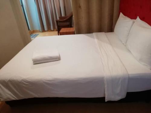 a white bed with a napkin on top of it at SUNTEC HOTEL in Johor Bahru