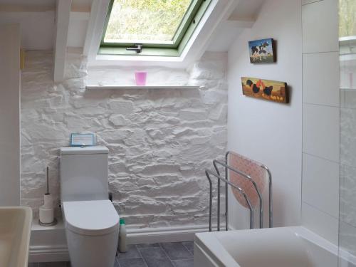 uma casa de banho com um WC, um lavatório e uma janela em Reubens em Moreleigh