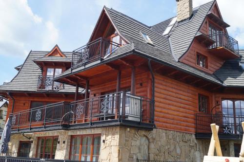 a large wooden house with balconies on top of it at Good Morning Giewont & JACUZZI in Kościelisko
