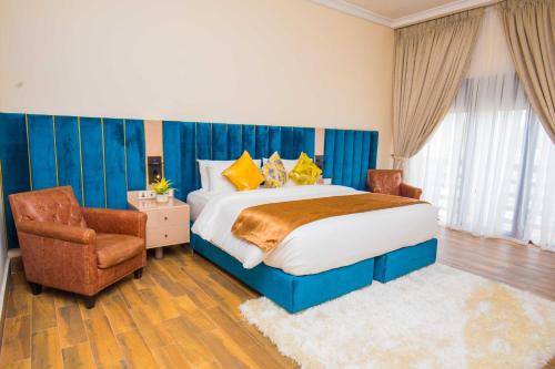 a bedroom with a large bed and a chair at Qlets Privé in Abuja
