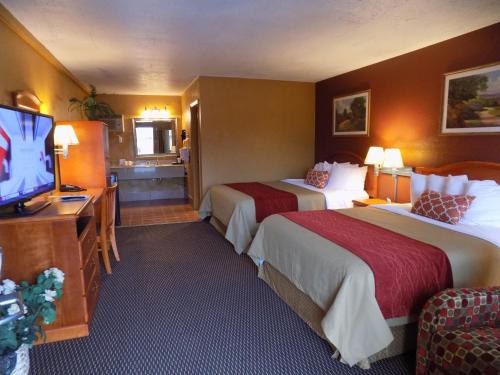 a hotel room with two beds and a flat screen tv at Virginia Inn in Lawrence
