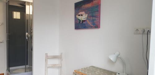 a bathroom with a painting on the wall and a lamp at Gazelle Guest House and Art Gallery in Ruffec