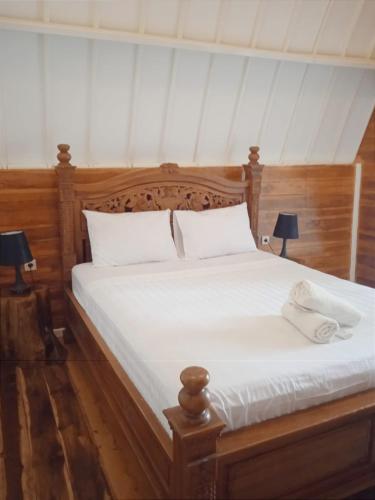a bedroom with a bed with white sheets and two lamps at LUCKY'S in Gili Air