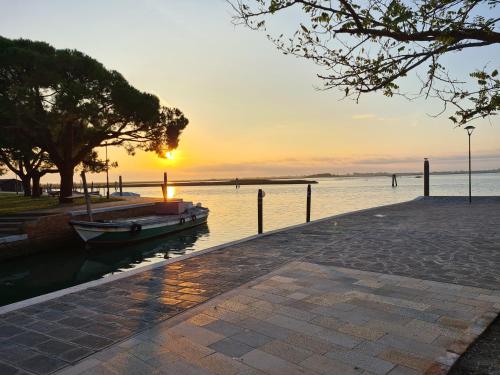 a boat on the water with the sunset in the background at Ca' Nova - Burano in Burano