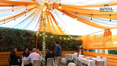 a group of people sitting at tables under a tent at Hotel Mediterraneo Arequipa in Arequipa