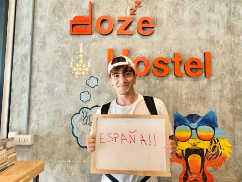 a man is holding a sign that says i loveoled at Doze Hostel in Chiang Mai