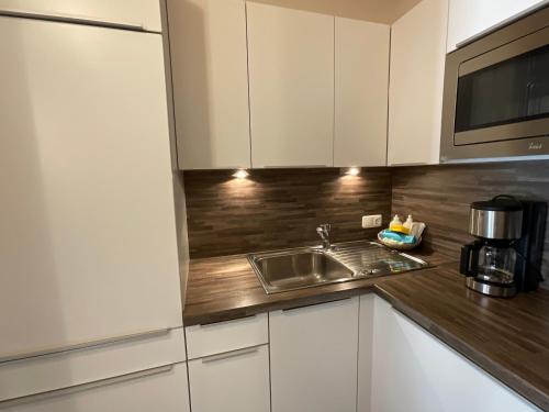 a kitchen with a sink and a microwave at Appartements Am Burgsee in Ladis