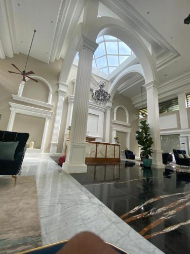a large room with columns and a couch and a ceiling at Nambiar Club Bellezea in Bengaluru