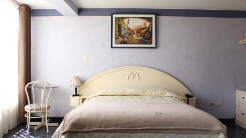 a bedroom with a bed and a painting on the wall at Hotel Mediterraneo Arequipa in Arequipa