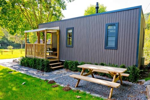 a tiny house with a picnic table and a bench at Chalet Fuusslee in Goebelsmuhle