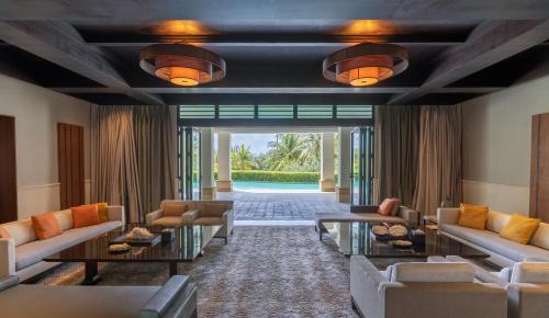 a lobby with couches and tables and a pool at Raffles Hainan Clear Water Bay in Sanya