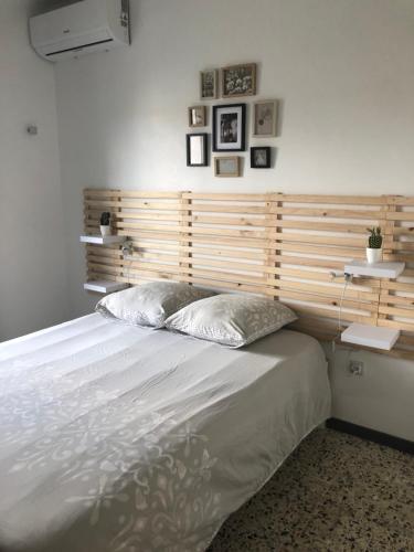 a bedroom with a large bed with a wooden headboard at Au Bougainvillier in Perpignan