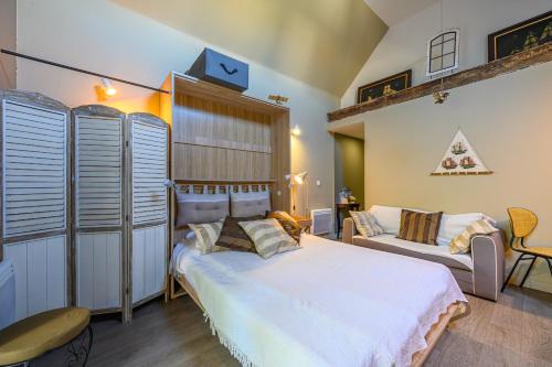 ル・ギルヴィネックにあるL'Ecloseのベッドルーム(大きな白いベッド1台、ソファ付)