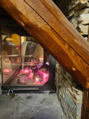a stone fireplace with pink flowers in it at Le Hameau des Ecrins Station 1800 in Puy-Saint-Vincent