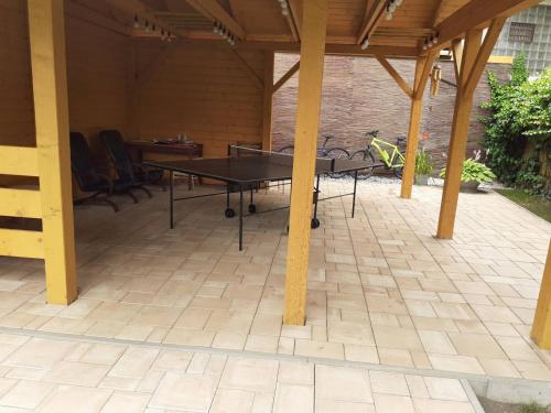 a ping pong table on a patio under a roof at Apartmány Lea in Liptovský Mikuláš