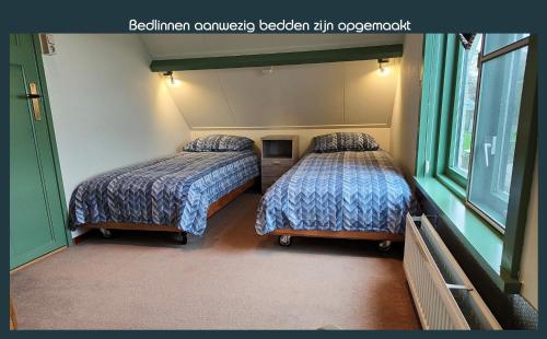 twee bedden in een kamer met twee ramen bij Vakantiewoning Deltahof in Ellewoutsdijk