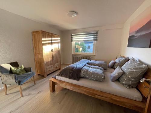 ein Schlafzimmer mit einem Bett mit Kissen und einem Fenster in der Unterkunft Ferienwohnung Elfengast, FassSauna, Harzurlaub in bester Lage in Bad Harzburg