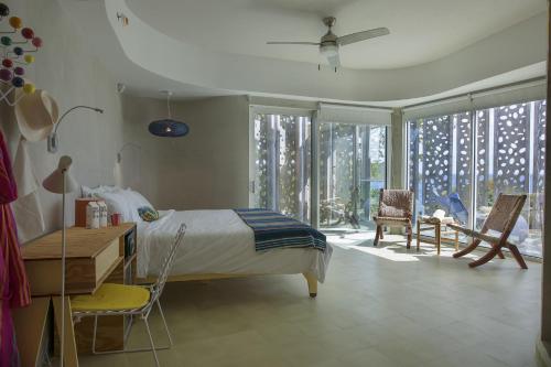 1 dormitorio con 1 cama, escritorio y sillas en El Blok, en Vieques