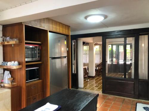 a kitchen with wooden cabinets and a stainless steel refrigerator at Chiangmai Lanna in San Kamphaeng