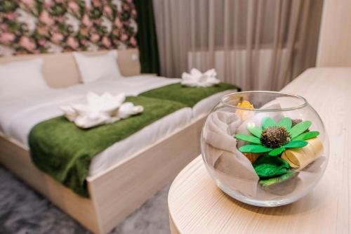 a room with a bed and a vase with a flower on a table at Пиргуля in Miladinowzi