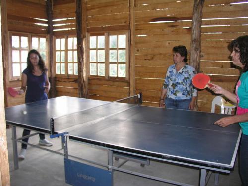 un grupo de personas de pie alrededor de una mesa de ping pong en El Rincón de San Agustín Etla, en San Agustín Etla