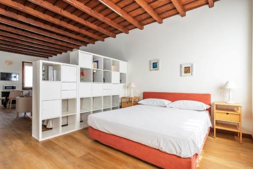 a bedroom with a white bed and white shelves at Italian Experience-Uriel Suite Apartment in Corteolona